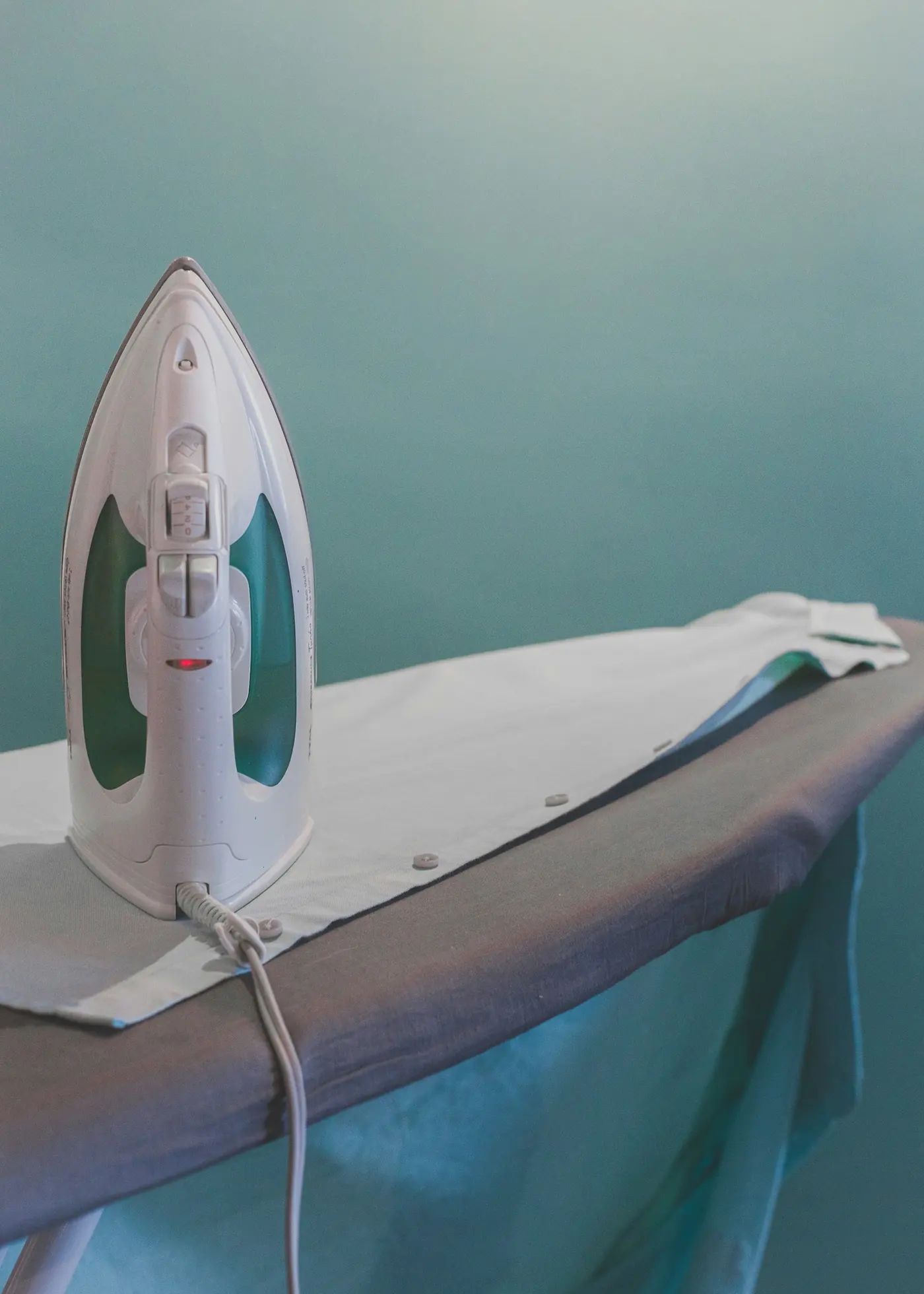 A steam iron resting on a pressed garment